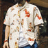 Person wearing a white shirt with vintage-style pin-up girl print, with tattoos visible on arms.